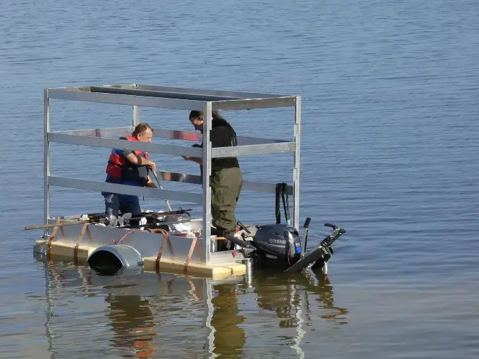 Ein PKW Anhänger mit zwei Personen der auf dem Wasser schwimmt Der Trailer mit Klaus Schulz (li.) und Kai Sommer (re.) auf dem Wasser hat alle Tests bestanden. (Foto: RES:Q / TM)